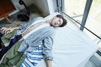 Jonghyun tampak tiduran di ranjang. (FNC Entertainment)