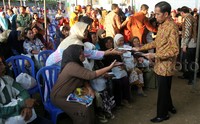 Jokowi membagikan buku tulis.