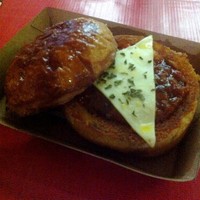 Chili Dip menu yang disajikan gerai​ Eat me. Roti bun dibelah dan iisi dengan campuran potongan kentang,daging,jamur yang diberi saus BBQ pedas. Diatasnya terdapat keju cheddar dan taburan daun​peterseli.​