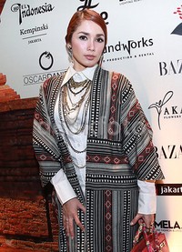 Ia memadukan outerwear tenunnya dengan kemeja putih dan aksesori kalung. Pool/Palevi S/detikFoto.