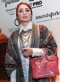 Ussy melengkapi penampilannya dengan aksesori anting dan cincin serta tas Hermes pink yang melingkar di tangan kirinya. Pool/Palevi S/detikFoto.