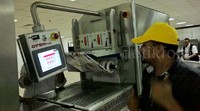 Koki melakukan pengepakan menggunakan mesin.