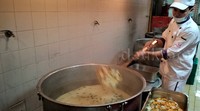 Seorang koki sedang memasak sayur.