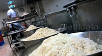 Seorang koki sedang memasak nasi.