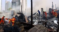 Petugas Damkar mendinginkan api di lokasi kebakaran.