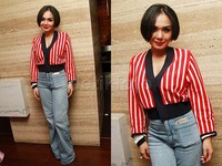 Yuni Shara tampil dengan baju garis-garis merah dan putih dipadu jeans. Pool/Gus Mun/detikFoto.
