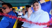 Lucy Kurniasari melambaikan tangan dari dalam kereta kelinci.