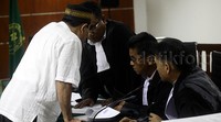 Syamsir berdiskusi dengan kuasa hukumnya.