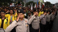 Mahasiswa dan polisi memberikan penghormatan saat bendera merah putih di halaman Istana Negara diturunkan.
