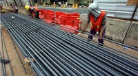 Sejumlah pekerja menyiapkan besi-besi yang akan digunakan untuk membuat kerangka tiang penyangga jalan layang.