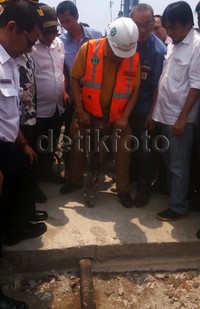 Dia menghancurkan beton yang menutup rel.