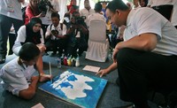 Anies Baswedan berinteraksi dengan pelukis disabilitas menggunakan kaki. Humas Kemendikbud/Budi Pambudo.