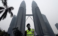 Seorang petugas keamanan berjaga dengan memakai masker. Pool/Maman Vatsyayana/AFP/detikFoto.