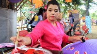 Seorang wanita dari stand Thailand melakukan demonstrasi melukis payung.