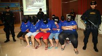Para tersangka dihadirkan dengan penjagaan ketat petugas bersenjata laras panjang.