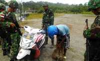 TNI memeriksa barang bawaan pengendara sepeda motor. Ist/Puspen TNI.