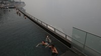 Sejumlah wisatawan berenang saat kabut asap menyelimuti Singapura. Edgar Su/Reuters/detiKFoto.