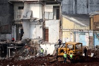 Sejumlah alat berat melakukan proses pemerataan tanah usai pembongkaran bangunan di belakang rusun Jatinegara Barat, Jakarta, Selasa (15/9/2015).