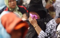Seorang ibu guru menutupi wajahnya.