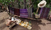 Seorang warga menggelar hasil kerajinan mulai dari topi, kain hingga tas.
