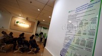 Papan berisi simulasi perbandingan pengenaan pajak atas pengambilan JHT secara sekaligus dan bertahap terpampang di ruang pelayanan.