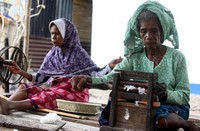 Dua orang perajin menyiapkan bahan untuk pembuatan kain tenun.
