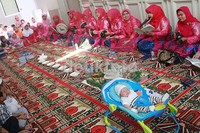 Sang buah hati tampak tertidur pulas walaupun ibu-ibu pengajian dan tamu undangan mulai menyanyikan lagu-lagu bernapaskan Islam. Pool/Gus Mun/detikFoto.