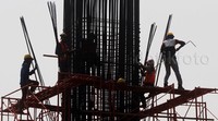 Sejumlah pekerja membuat tiang penyangga jalan layang.