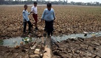 Anak-anak bermain di setu yang mengering.