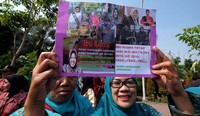 Warga membawa foto-foto Risma saat menjabat sebagai Wali Kota Surabaya.