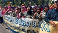 Warga membentangkan spanduk dukungan untuk Risma.