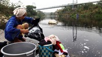 Warga terpaksa mencuci di sungai karena sumurnya mengering akibat kemarau panjang.