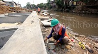 Proses pengerjaan dinding turap di Kampung Pulo saat ini tengah dilakukan oleh sejumlah pekerja.