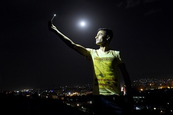 Seorang pria melakukan selfie mengabadikan fenomena bulan darah di Afganistan. (istimewa/detikcom/gettyimages)