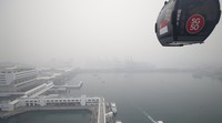 Kereta gantung melintas di tengah kabut asap yang menyelimuti Mount Faber dan Pulau Sentosa.