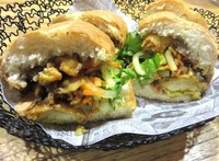 Banh mi berisi fillet ikan lele bumbu kunyit, pate (lumatan hati ayam), mayonnaise, acar wortel, timun, irisan bawang bombay dan daun ketumbar segar. Baguette empuk cocok dengan daging lele goreng tepung yang gurih lembut. Tercecap bumbu ngohiong pada isian banh mi.