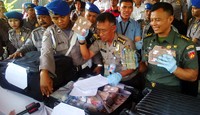 Polisi menunjukkan barang bukti uang.