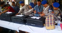 Polisi menunjukkan koper yang berisi barang bukti uang.