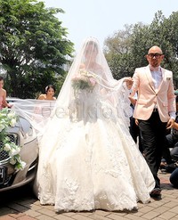 Ia terlihat memesona dalam balutan gaun pengantin putih yang mewah.