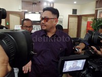 Ia tampil dengan kemeja ungu, kacamata hitam serta potongan rambut ala Kim Jong-un.