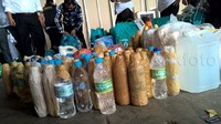 Botol-botol berisi air zam-zam dikeluarkan dari dalam koper.