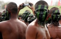 Seorang prajurit yang wajahnya telah diberi warna hujau dan hitam tampak melakukan selfie di saat sebelum memulai gladi bersih.     
