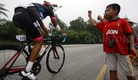 Seorang anak memberikan semangat kepada pebalap.
