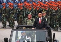 Presiden Jokowi yang berjas dan memakai peci kemudian mengecek pasukan dengan didampingi Panglima TNI Jenderal Gatot Nurmantyo. Dia mengecek dari atas mobil jeep yang berjalan.