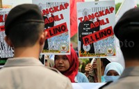 Massa membentangkan poster-poster tuntutan.