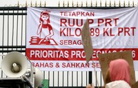 Para PRT memasang spanduk tuntutan di gerbang DPR.