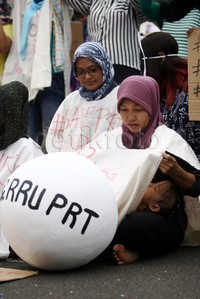 Salah seorang PRT membawa anaknya untuk ikut aksi di depan Gedung DPR.