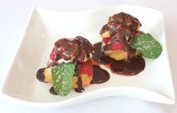 Profiteroles with Warm Chocolate Sauce menjadi sajian pencuci mulut. Choux pastry dengan tekstur garing diisi es krim vanilla. Permukaan profiteroles diberi guyuran cokelat pekat.