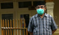 Seorang warga beraktivitas menggunakan masker.
