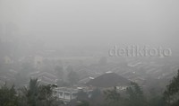 Rumah-rumah warga nyaris tak terlihat karena tertutup asap pekat.